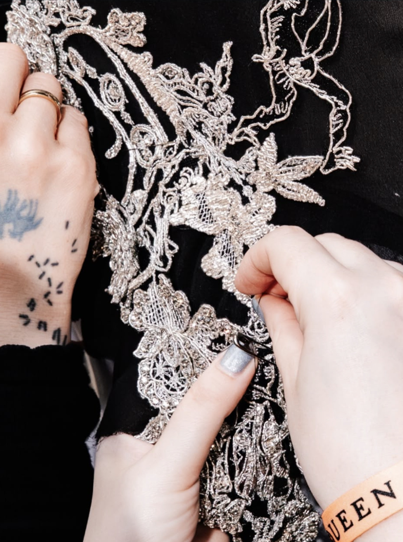 Silver embroidery being worked by hand backstage at Alexander McQueen, Paris Fashion Week